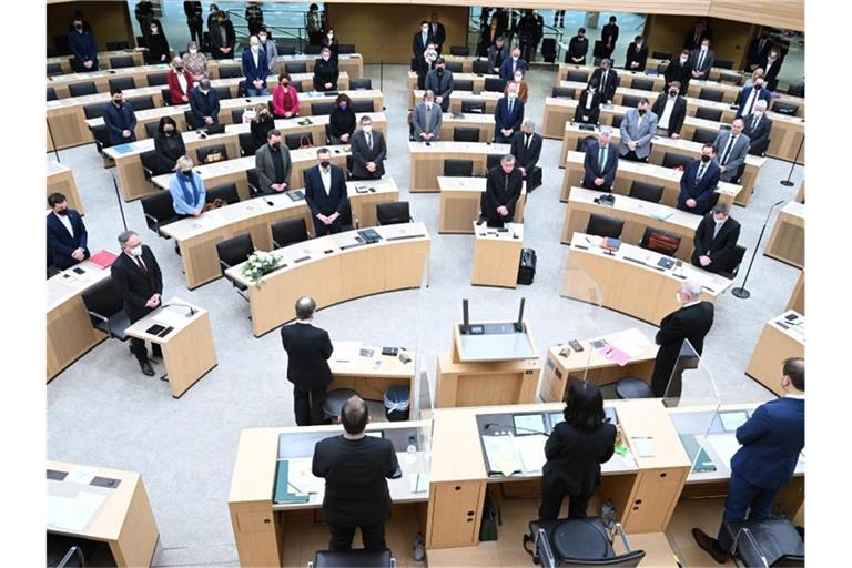 Abgeordnete des Landtags von Baden-Württemberg stehen bei einer Schweigeminute für den verstorbenen Landtagsabgeordneten Hans-Ulrich Sckerl (Bündnis 90/Die Grünen). Foto: Bernd Weißbrod/dpa