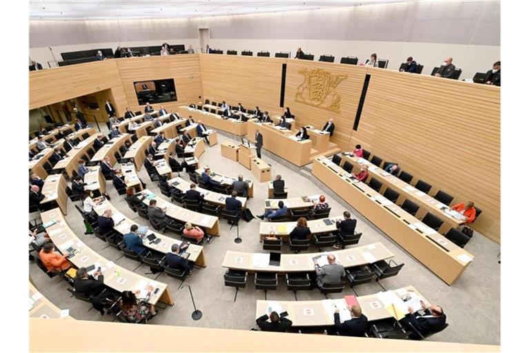 Abgeordnete sitzen im Plenarsaal des Landtags von Baden-Württemberg. Foto: Bernd Weißbrod/dpa