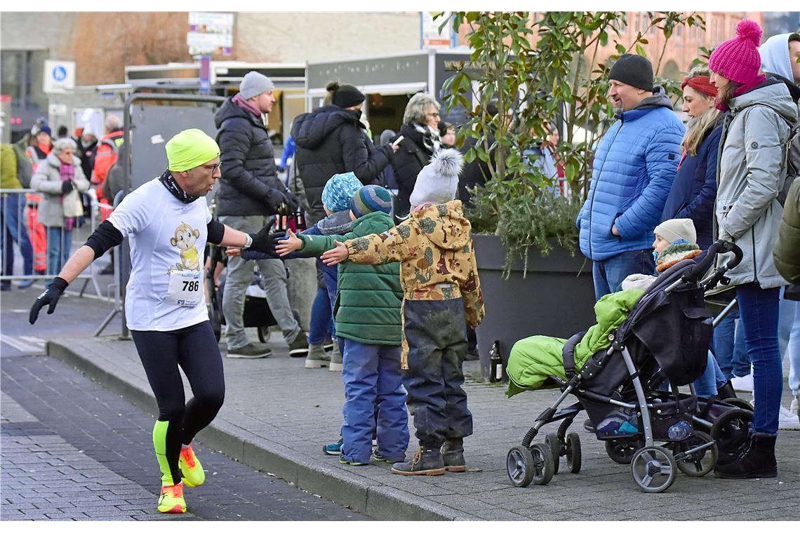 Abklatschen bei den Fans am Straßenrand. Silvesterlauf 2024 in Backnang. SP