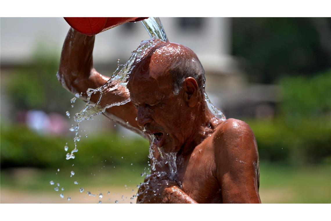 Abkühlung über Kopf: In einem Park pakistanischen Karachi begießt sich ein Mann mit Wasser. Die dortigen Behörden warnten vor Temperaturen bis zu 50 Grad, schlossen Schulen und forderten die Anwohner auf, in ihren Häusern zu bleiben.