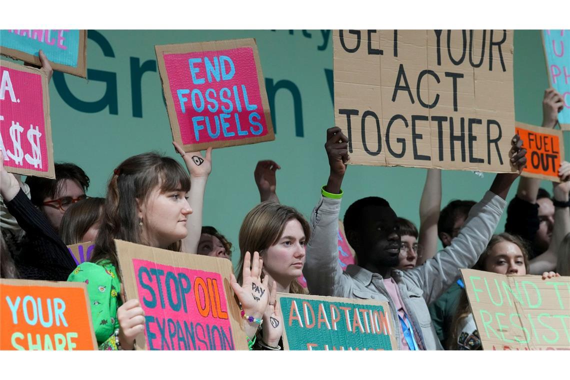 Aktivisten halten Plakate bei einer Demonstration gegen fossile Brennstoffe auf dem UN-Klimagipfel COP29.