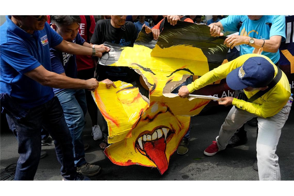 Aktivisten zerreißen auf den Philippinen einen Banner der eine Karikatur des chinesischen Präsidenten Xi Jinping zeigt. Die Gruppe protestiert gegen die anhaltende Aggression Chinas im umstrittenen Südchinesischen Meer.