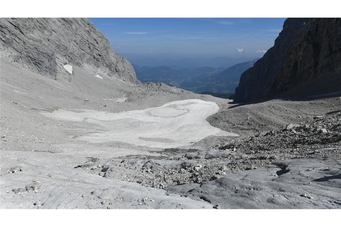 Altschnee und Geröll liegen auf dem kleinen Überrest des Watzmanngletschers. Der Gletscher auf über 2000 Metern Höhe im oberen Watzmannkar schrumpft und wird wahrscheinlich in einigen Jahren verschwunden sein.