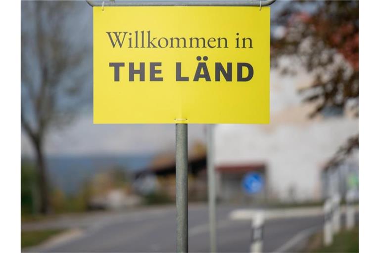 Am Ortsschild von Dischingen hängt ein Zusatzschild mit der Aufschrift „Willkommen in THE LÄND“. Foto: Stefan Puchner/dpa/Archivbild