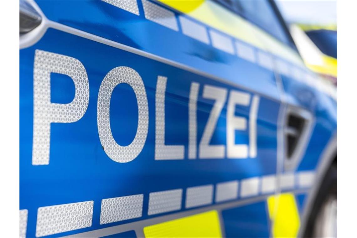 An der Tür von einem Streifenwagen steht der Schriftzug „Polizei“. Foto: David Inderlied/dpa/Symbolbild