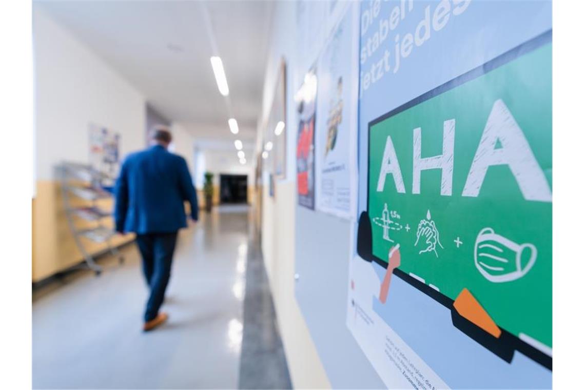 Sieben-Tage-Inzidenz steigt erneut auf Höchstwert An der Wand eines Flurs in einem Gymnasium ist ein Hinweis auf die AHA-Regeln angebracht. Foto: Nicolas Armer/dpa