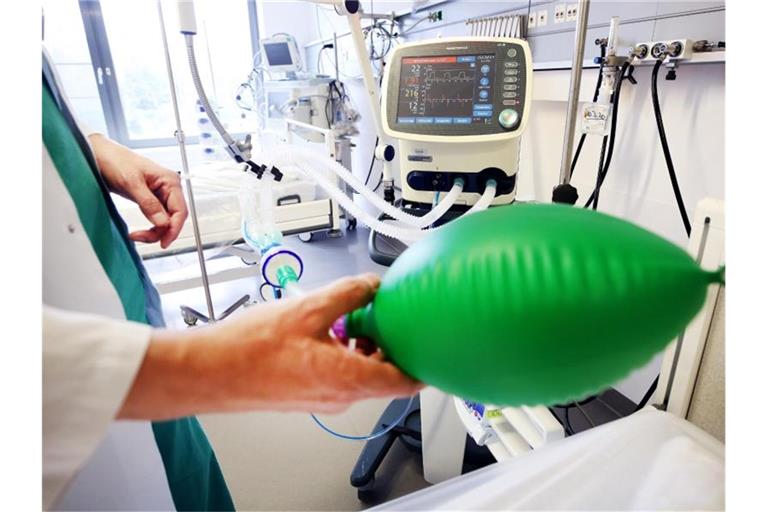 An einem Intensivbett für Corona-Patienten zeigt ein Arzt die Funktionsweise eines Beatmungsgerätes. Foto: Roland Weihrauch/dpa/Archivbild