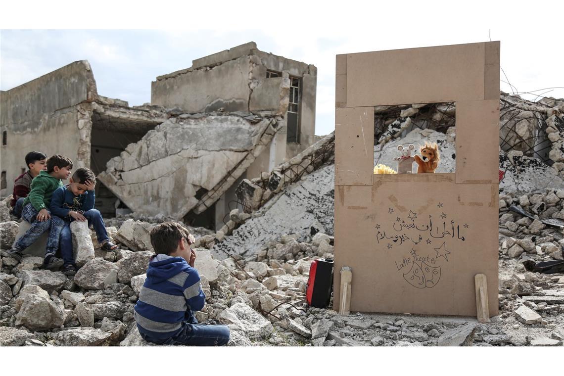 Anas Alkharboutli fotografierte einen Puppenspieler, der in den Trümmern ein Marionettentheater aufführt.