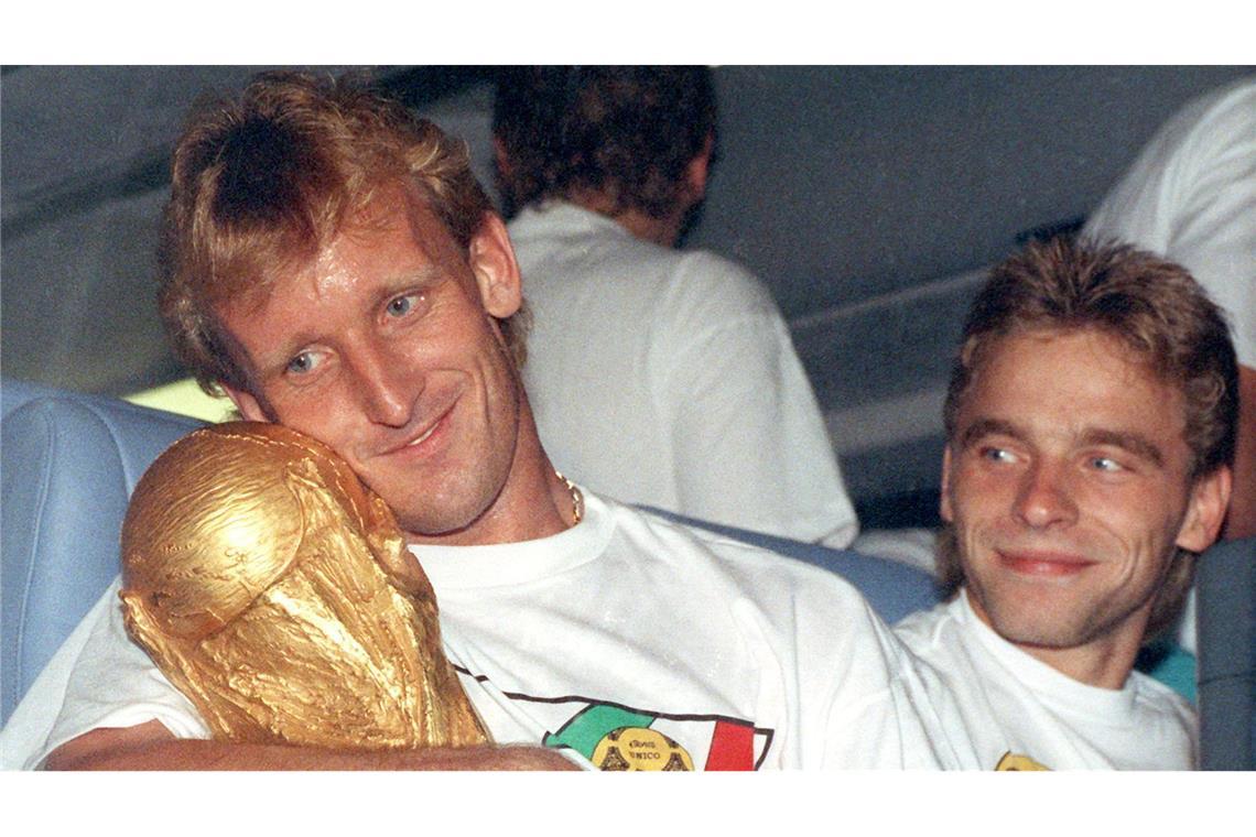 Andreas Brehme (l) mit dem WM-Pokal nach dem Finalsieg 1990 gegen Argentinien. Rechts daneben sein Mitspieler Thomas Häßler.
