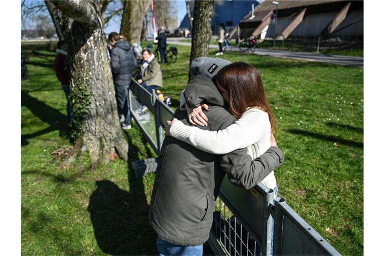 Andy aus Deutschland und Olivia aus der Schweiz umarmen sich an der Deutsch-Schweizer Grenze. Foto: Felix Kästle/dpa