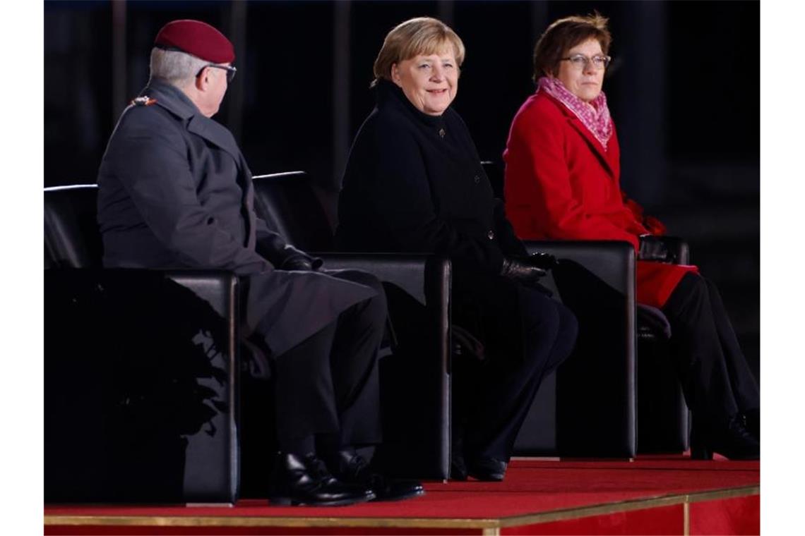 Großer Zapfenstreich für Merkel: „Farbfilm“ und etwas Gefühl Angela Merkel die Zeremonie zusammen mit Verteidigungsministerin Annegret Kramp-Karrenbauer und dem Generalinspekteur der Bundeswehr, General Eberhard Zorn. Foto: Odd Andersen/AFP POOL/dpa