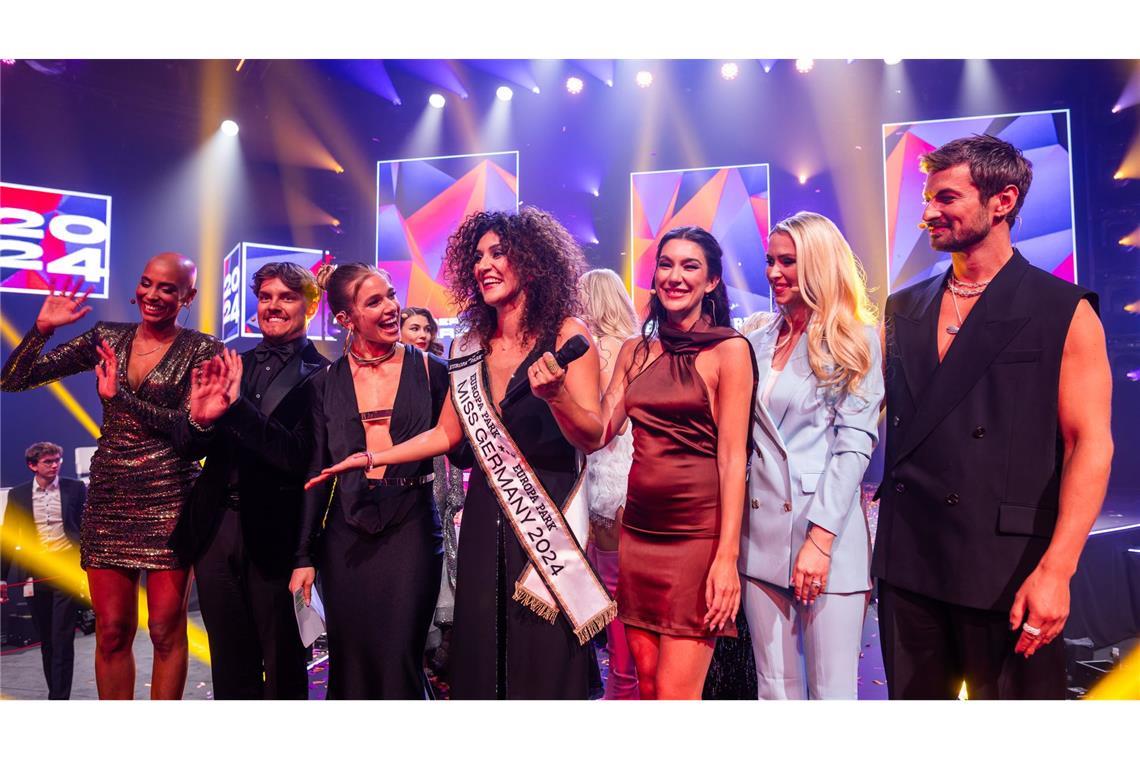 Apameh Schönauer (4.v.l.) feiert gemeinsam mit Sharon Battiste (l-r), Tim „Twenty4Tim“ Kampmann, Lola Weippert, Neda Peemüller, Vivien Wulf und Nicolas Puschmann ihren Titelgewinn als Miss Germany 2024. (Archivbild)