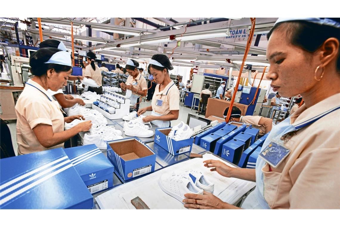 Arbeiterinnen in Phnom Penh stellen Schuhe für Adidas her.