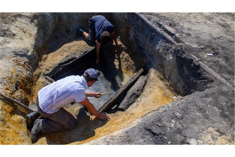 Archäologen vom Landesamt für Denkmalpflege und Archäologie Sachsen-Anhalt legen auf einer Grabungsfläche einen mittelalterlichen Holzbrunnen frei.