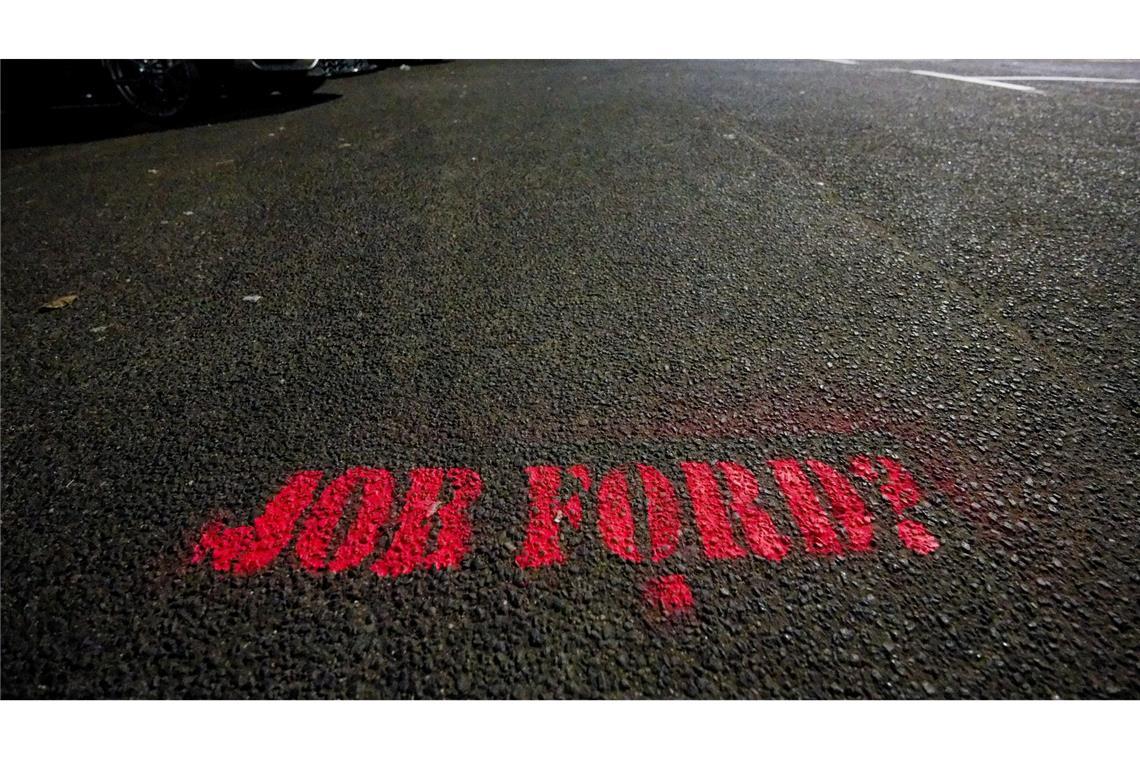 Auf dem Asphalt eines Parkplatzes vor den Fordwerken in Köln steht "Job Ford?".