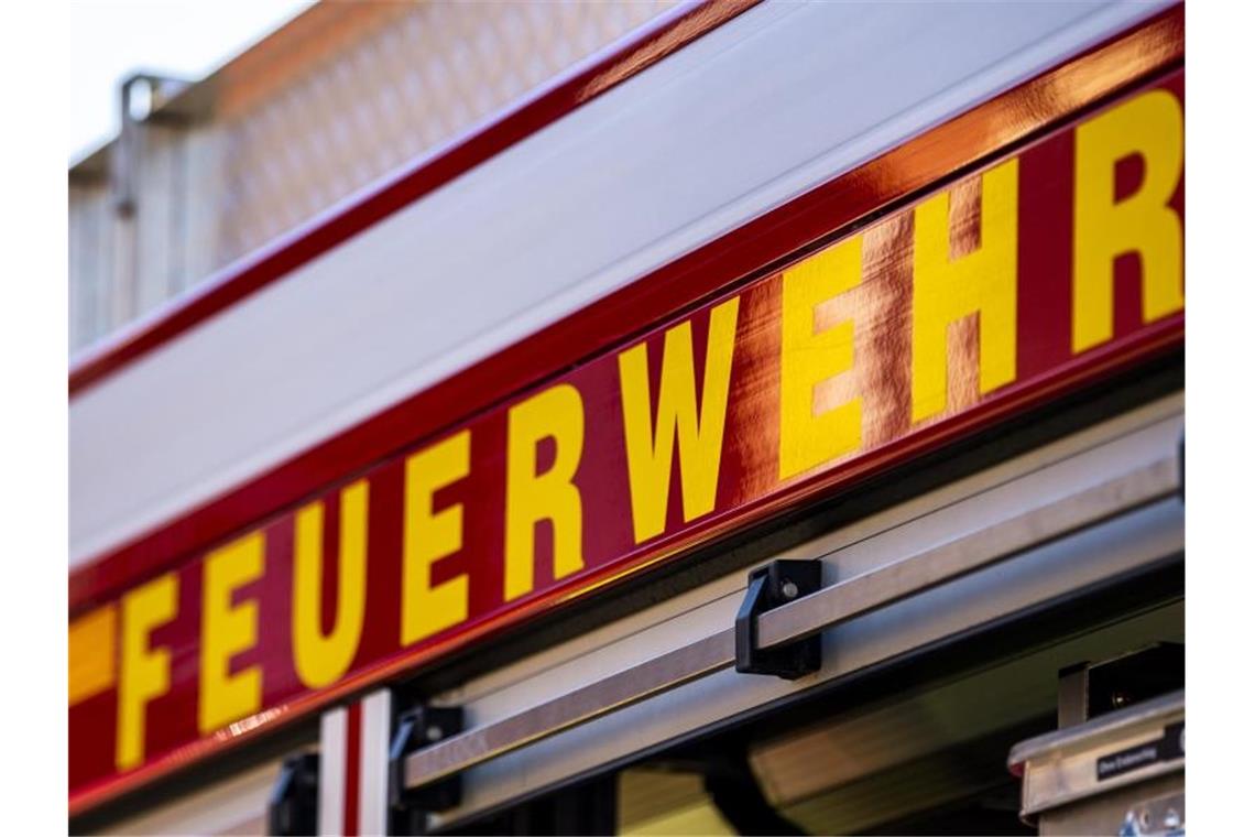 Auf dem Einsatzfahrzeug ist in gelber Farbe der Schriftzug „Feuerwehr“ zu lesen. Foto: David Inderlied/dpa/Symbolbild