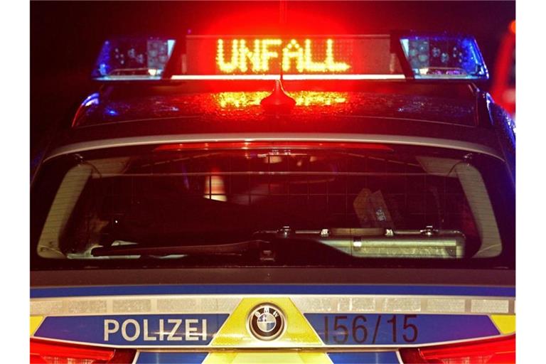 Auf der A8 spiegeln sich während einer Unfallaufnahme das Blaulicht und der LED- Schriftzug "Unfall" auf dem nassen Dach eines Polizestreifenwagens. Foto: Stefan Puchner/dpa/Symbolbild