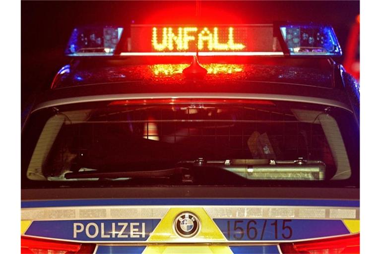 Auf der A8 spiegeln sich während einer Unfallaufnahme das Blaulicht und der LED- Schriftzug "Unfall" auf dem nassen Dach eines Polizestreifenwagens. Foto: Stefan Puchner/dpa/Symbolbild