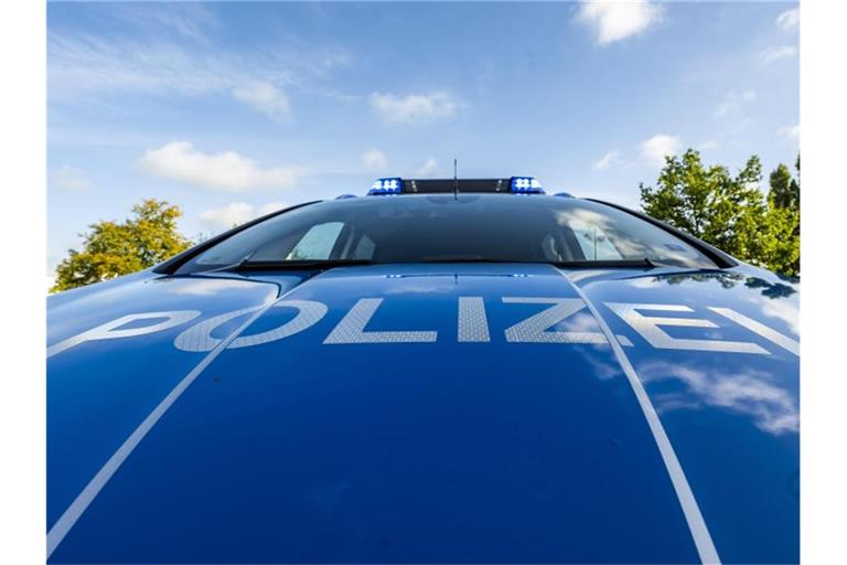 Auf der Motorhaube eines Streifenwagens steht der Schriftzug „Polizei“. Foto: David Inderlied/dpa/Illustration