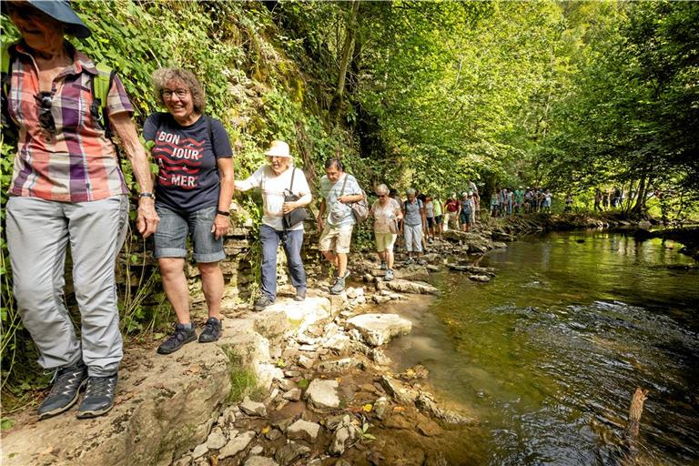 Auf einem schmalen Pfad wandern die rund 60 Teilnehmerinnen und Teilnehmer am Bach entlang. Fotos: Alexander Becher