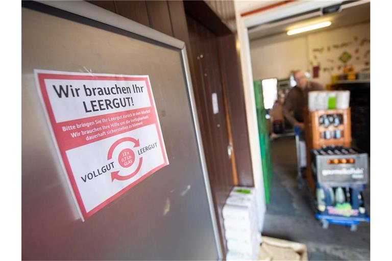 Auf einem Zettel steht in einem Getränkemarkt „Wir brauchen Ihr Leergut“. Foto: Sebastian Gollnow/dpa/Archivbild