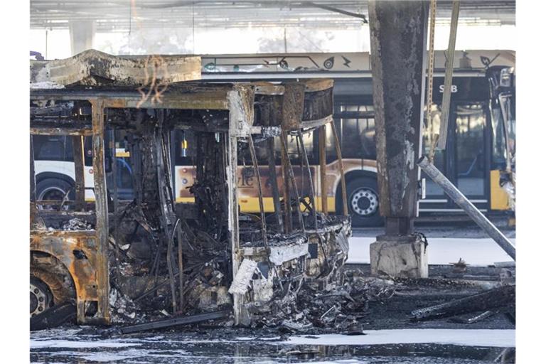 Ausgebrannte Busse stehen nach Löscharbeiten in einem Busdepot. Foto: Tom Weller/dpa/Archivbild