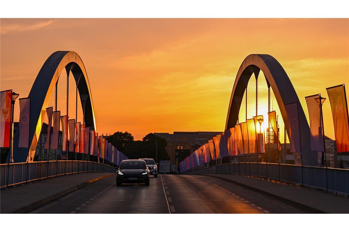 Autos fahren zum Sonnenaufgang über die Stadtbrücke über den Grenzfluss Oder zwischen Frankfurt und dem polnischen Slubice. Zum 20. Jahrestag des EU-Beitritts Polens wollen sich am Mittag die Außenminister der beiden Nachbarländer treffen.