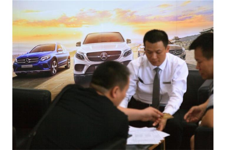 Autoverkäufer beraten Kunden in einem Autohaus von Mercedes-Benz in der chinesischen Stadt Guangzhou. Foto: Wenjun Chen/dpa