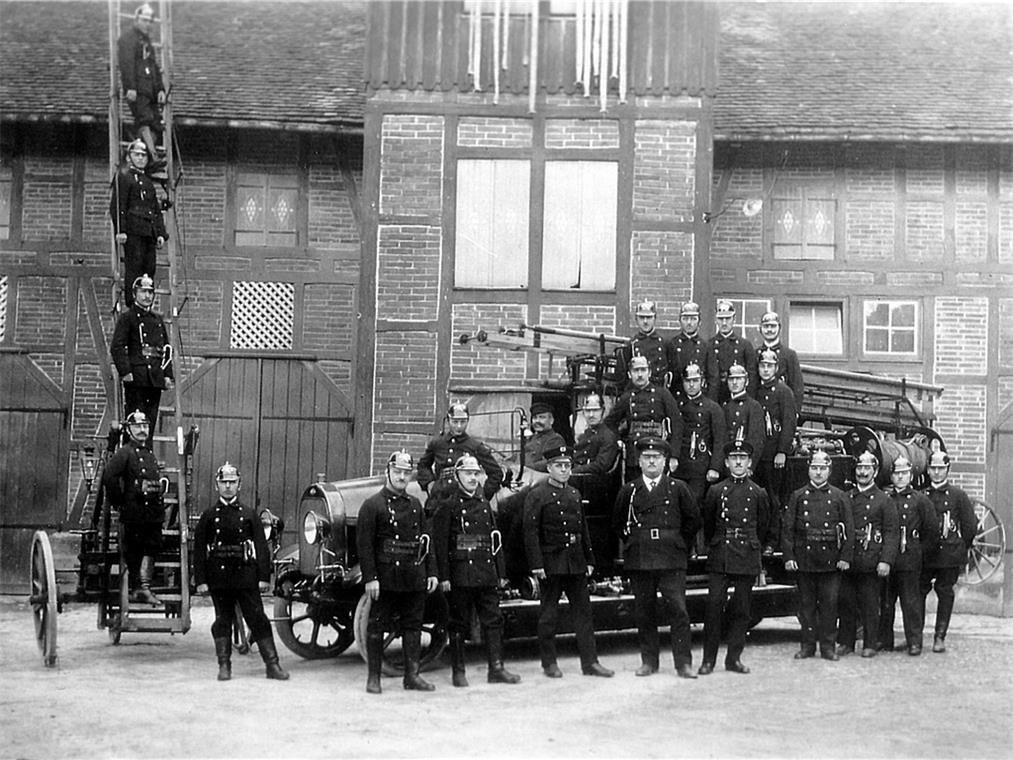 Der Konsum und die Feuerwehr Backnanger Feuerwehrmänner mit ihrer ersten Autofeuerlöschspritze 1924. Im Hintergrund das Feuerwehrgerätehaus (Feuerspritzenremise) mit Steigerturm am Adenauerplatz. Repros: P. Wolf