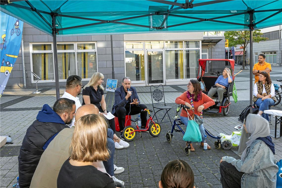 Backnangs Erster Bürgermeister Stefan Setzer erläutert die Positionen der Stadt zur Mobilität. Um das Thema zu veranschaulichen, hatten die Veranstalter den Platz im Biegel mit verschiedenen Gefährten dekoriert – vom Laufrad bis zur Fahrradrikscha. Foto: Dietmar van der Linden