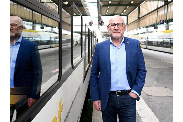 Baden-Württembergs Verkehrsminister Winfried Hermann steht vor einem Regionalzug. Foto: Bernd Weißbrod/dpa/archivbild