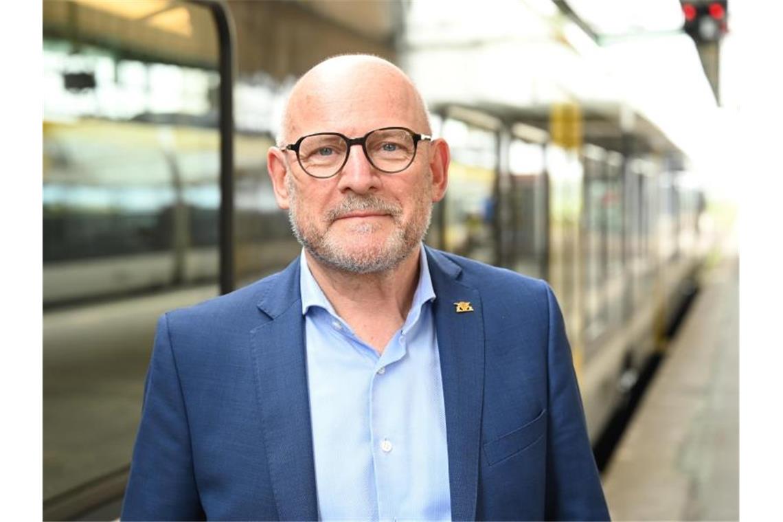 Baden-Württembergs Verkehrsminister Winfried Hermann steht vor einem Regionalzug. Foto: Bernd Weißbrod/dpa/Archivbild