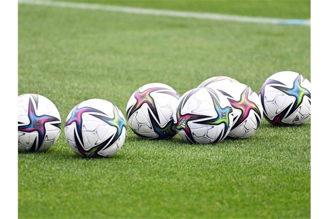 VfB-Trainer und das Grübeln: Abstiegskampf ist Kopfsache Bälle liegen auf einem Fußballplatz. Foto: Swen Pförtner/dpa/Symbolbild