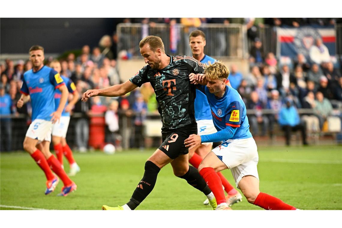 Bayerns Harry Kane (l-r) behauptet den Ball gegen Kiels Finn Porath.