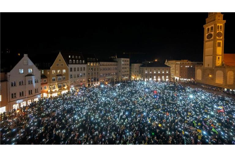 Bei einer Demonstration für Demokratie halten mehrere Tausend Menschen auf dem Rathausplatz in Augsburg Lichter hoch.