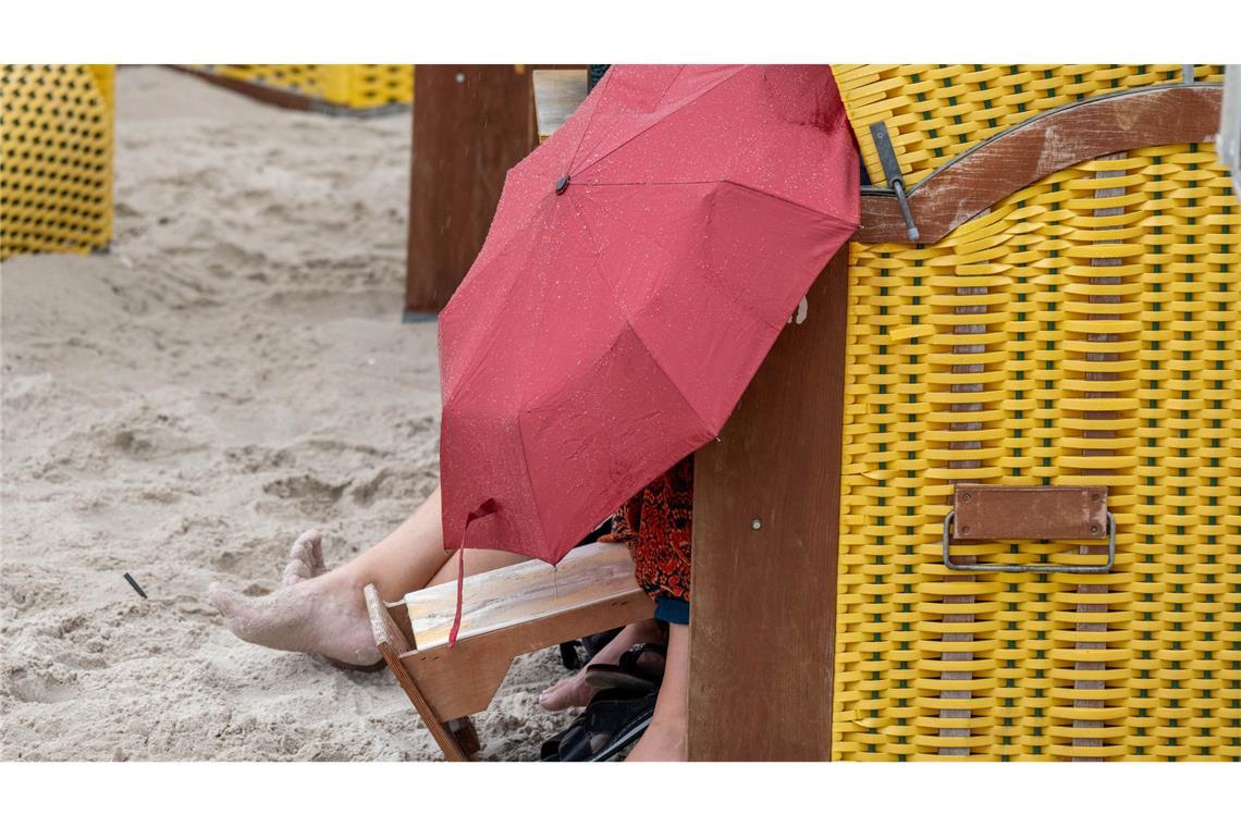 Bei Sturm und Regen im Strandkorb: Touristen suchen an der Ostsee Schutz vor Regen