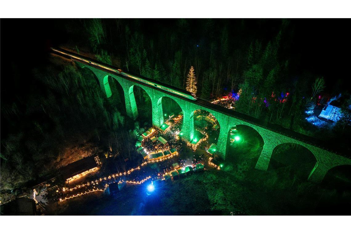 Beleuchtetes Eisenbahn-Viadukt der Höllentalbahn über dem Weihnachtsmarkt in der Ravennaschlucht.