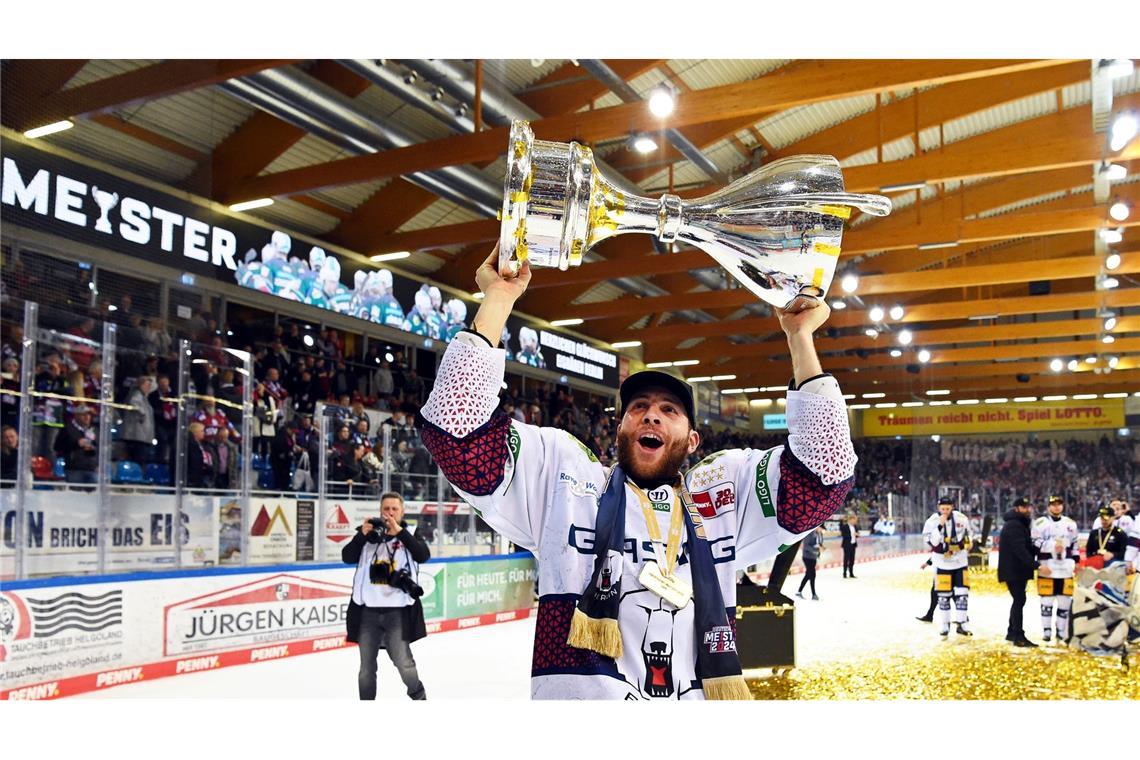 Berlins Yannick Veilleux jubelt nach dem Gewinn der deutschen Eishockey-Meisterschaft mit dem Pokal.