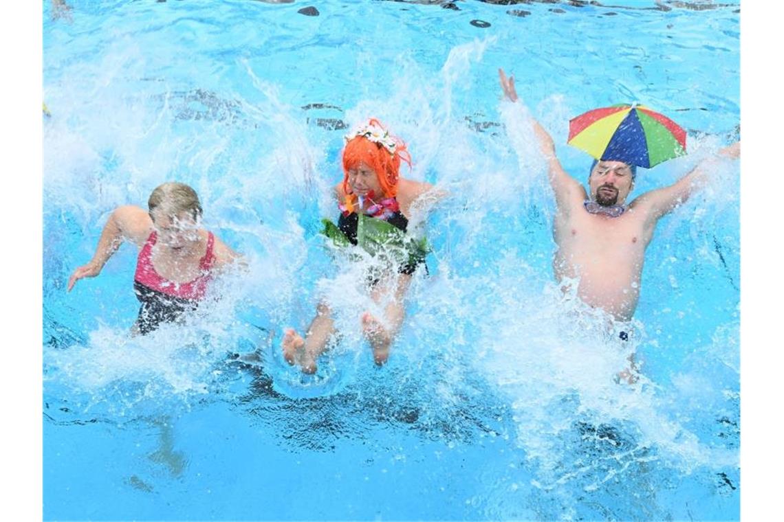 „Einfach nur toll“: Karlsruher Sonnebad startet Außen-Saison Besucher des Freibads "Sonnenbad" springen zur Eröffnung des Freibads in das Wasser des Beckens. Foto: Uli Deck/dpa