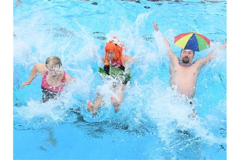 Besucher des Freibads "Sonnenbad" springen zur Eröffnung des Freibads in das Wasser des Beckens. Foto: Uli Deck/dpa