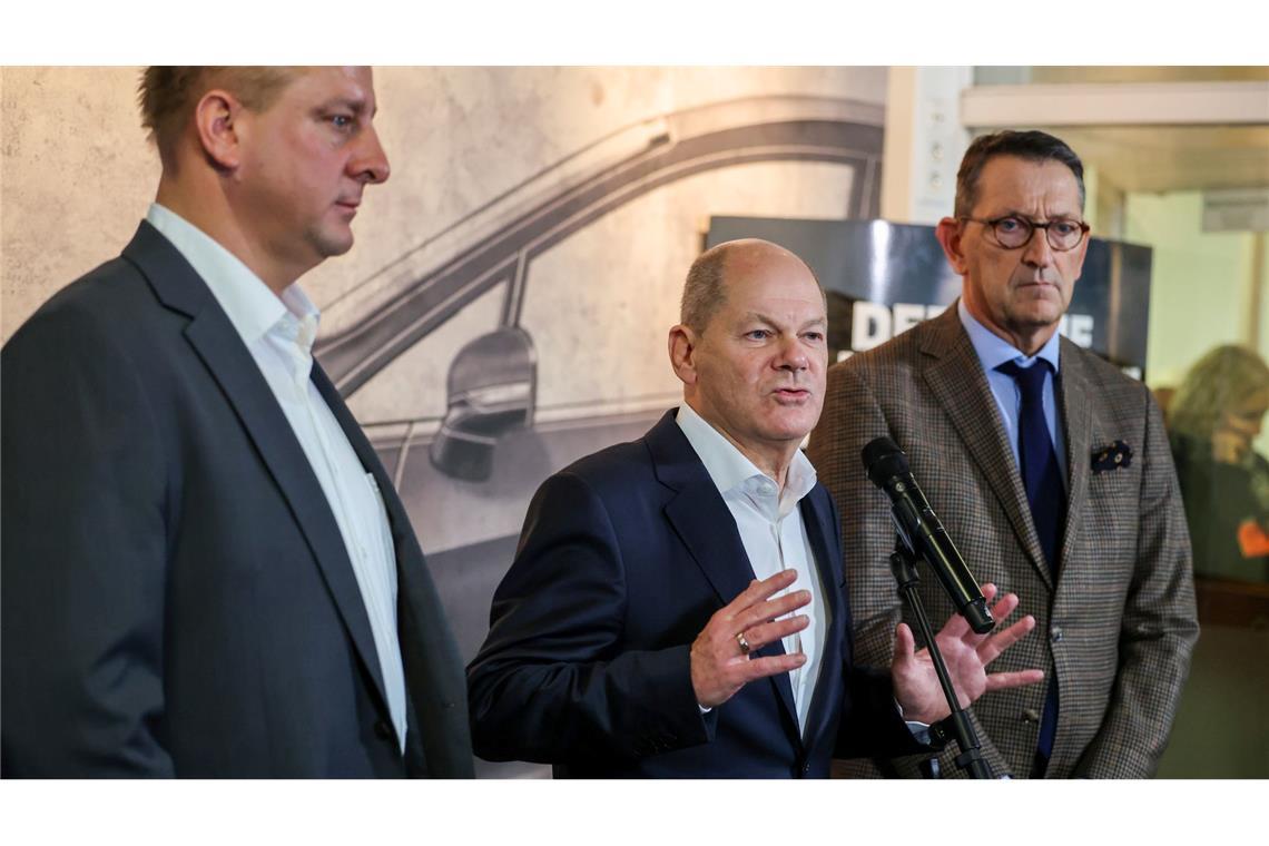 Betriebsratschef Benjamin Gruschka (l) neben Bundeskanzler Olaf Scholz (SPD) und Marcus Wassenberg (r), Geschäftsführer der Ford-Werke.