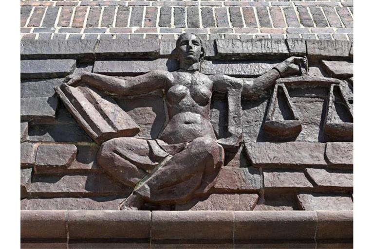 Blick auf die Justitia über dem Eingang eines Gerichts. Foto: Hendrik Schmidt/dpa-Zentralbild/dpa/Symbolbild