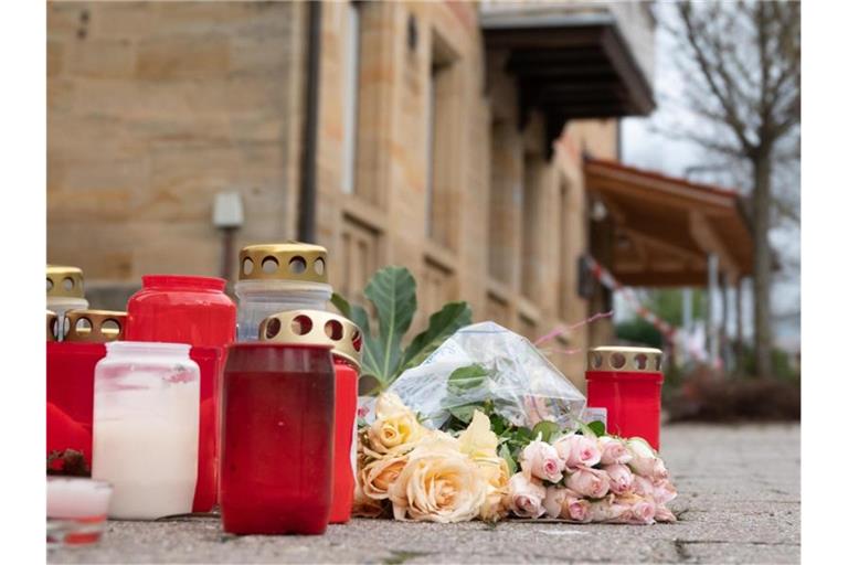 Blumen und Kerzen liegen vor dem Tatort in Rot am See. Foto: Gregor Bauernfeind/dpa/Archivbild