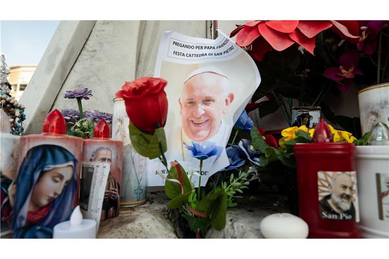 Blumen und Votivkerzen, einige mit dem Abbild von Papst Franziskus, liegen vor dem Gemelli-Krankenhaus in Rom.