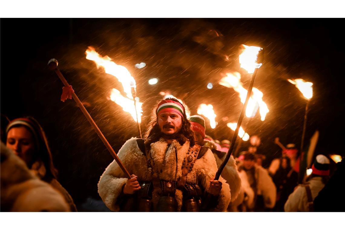 Bulgarische Kukeri-Tänzer halten ihre Fackeln beim Neujahrsritual Surva.