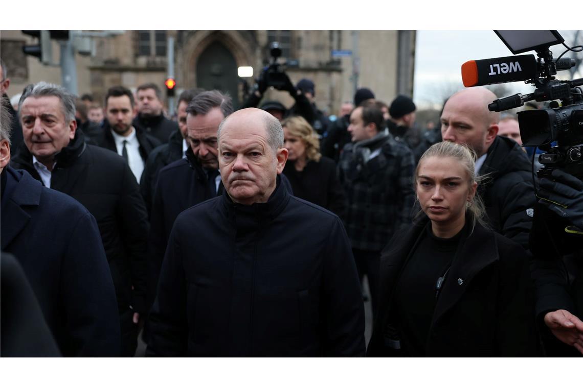 Bundeskanzler Olaf Scholz (M, SPD) und Volker Wissing (hinten, parteilos), Bundesminister für Digitales und Verkehr und Bundesminister der Justiz, besuchen den Ort der tödlichen Attacke auf dem Weihnachtsmarkt.