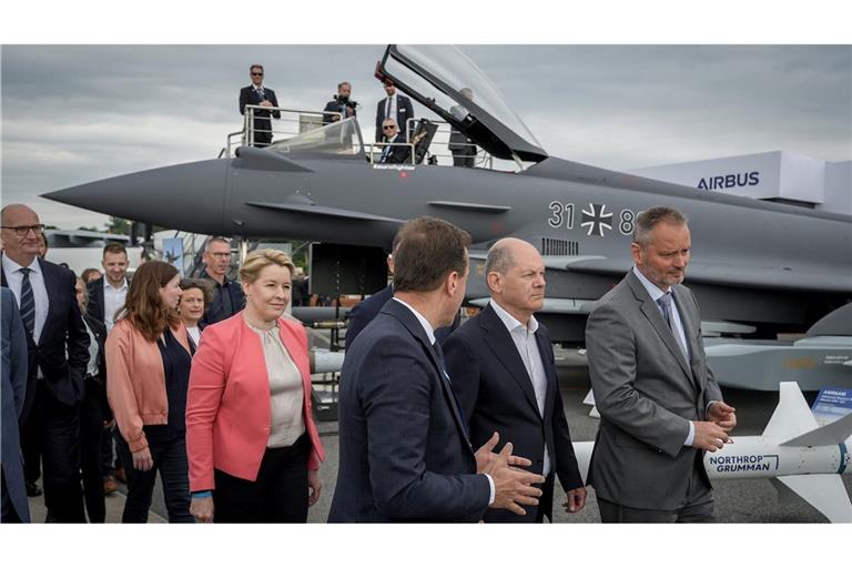 Bundeskanzler Olaf Scholz (SPD,2.v.r) auf der Internationalen Luft- und Raumfahrtausstellung (ILA) vor einem mit einem Taurus-Marschflugkörper bestückten Eurofighter.