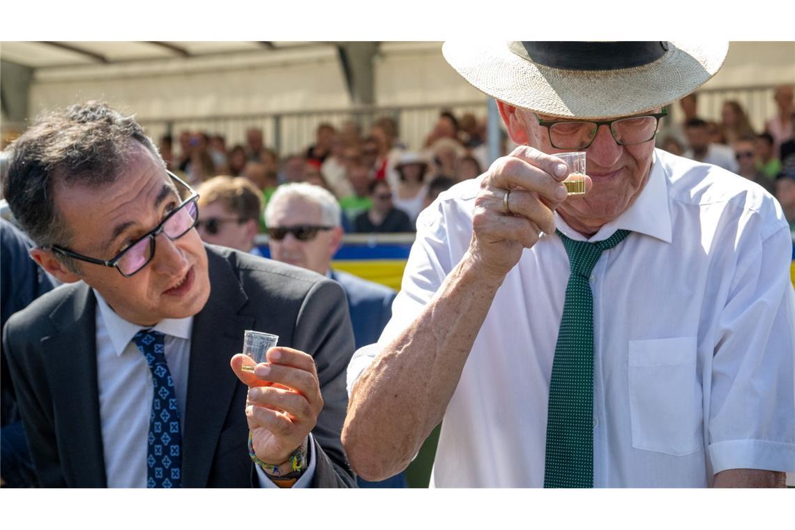 Bundeslandwirtschaftsminister Cem Özdemir (links) und der Baden-Württemberger Ministerpräsident Winfried Kretschmann prosten mit Probiergläschen bem Markgröninger Schäferlauf .