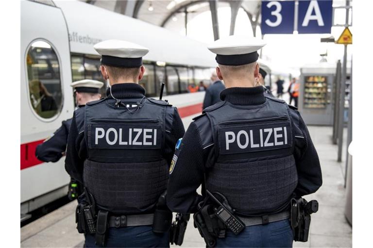 Bundespolizisten stehen vor der Abfahrt eines ICE an einem Gleis im Kieler Hauptbahnhof. In den Zügen der Deutschen Bahn wird die Mund-Nase-Bedeckungspflicht kontrolliert. Foto: Axel Heimken/dpa