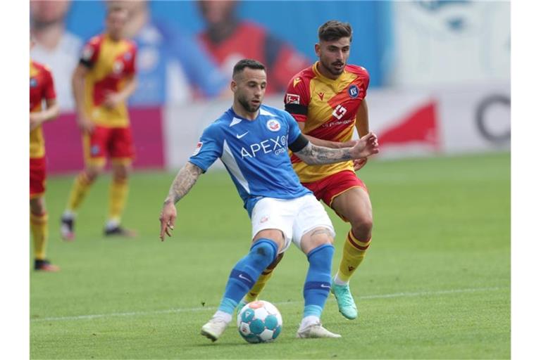 Calogero Rizzuto (l) vom FC Hansa Rostock im Kampf um den Ball mit Malik Batmaz vom Karlsruher SC. Foto: Danny Gohlke/dpa